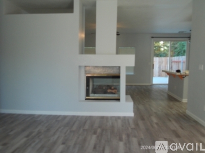 A living room with a fireplace and a person in the background.