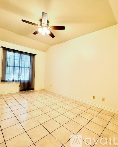 Empty room with tiled floor and ceiling fan.