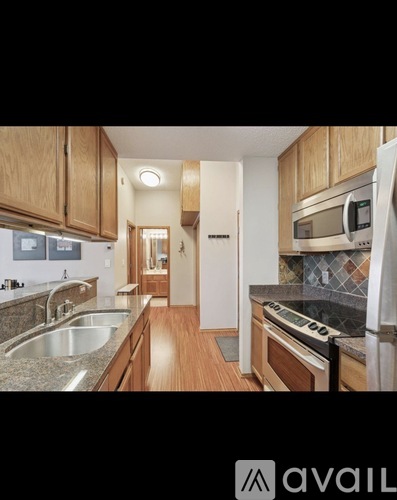 A kitchen with wooden cabinets and a granite countertop.