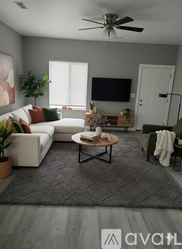 A living room with a white sofa, a coffee table, and a television.