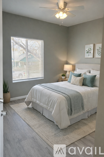 A bedroom with a bed, a ceiling fan, and a window with blinds.