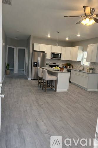 A kitchen with a refrigerator, microwave, and oven.