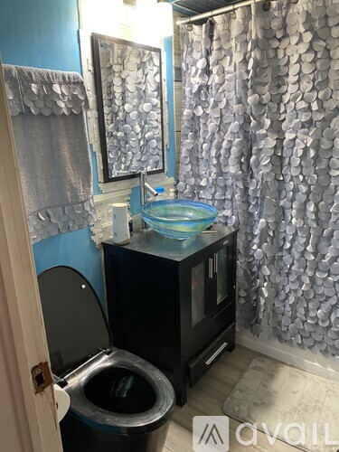 A bathroom with a toilet, sink, and shower curtain.