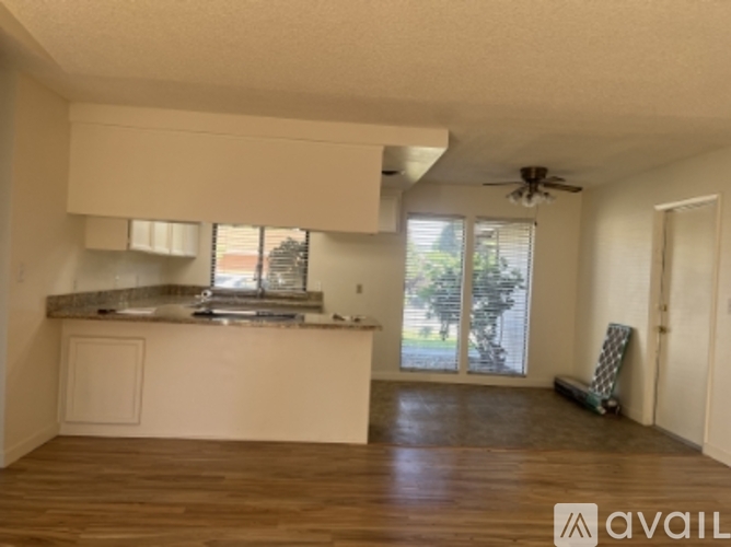 A kitchen with a counter and a fan on the ceiling.
