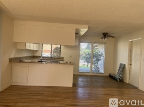 A kitchen with a counter and a fan on the ceiling.