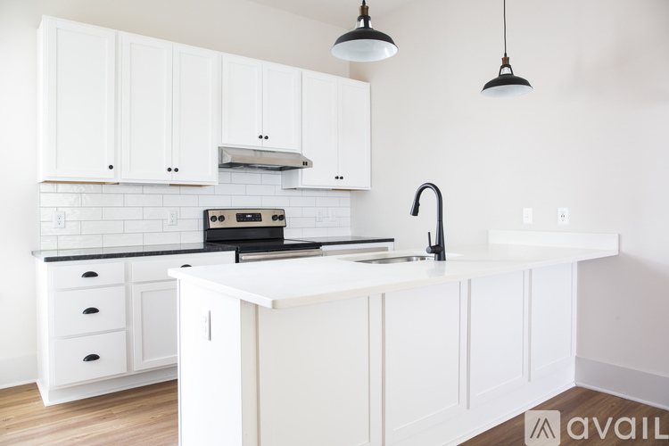 A kitchen with white cabinets and a black stove top oven.