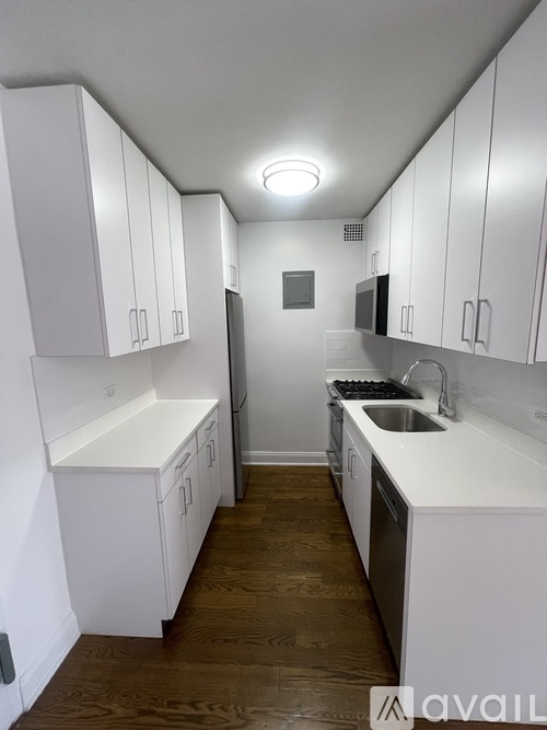 A kitchen with white cabinets and a sink.
