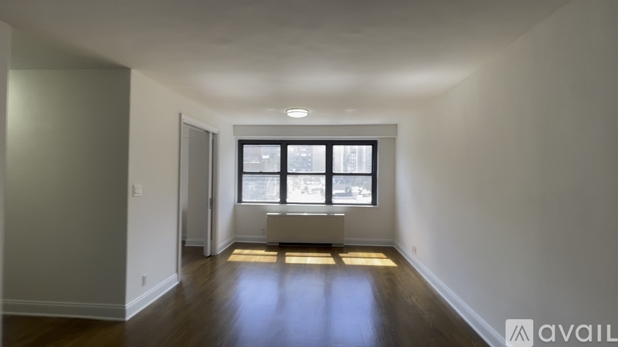 A room with a window and a radiator on the floor.