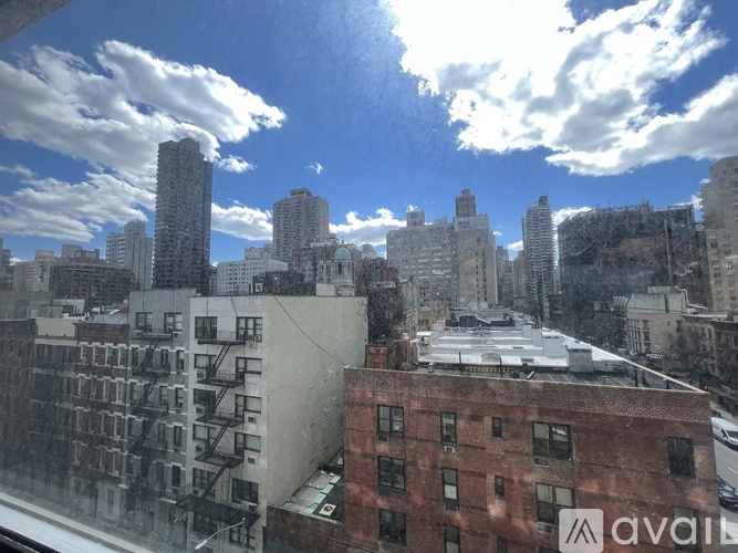 A cityscape with buildings and a cloudy sky.