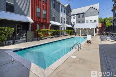 A swimming pool in a residential area surrounded by houses.