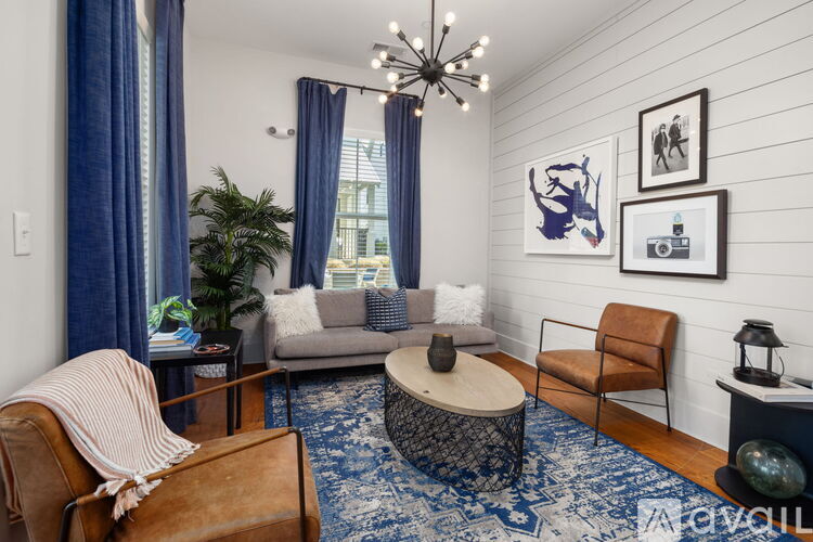A living room with a couch, chair, and a rug.