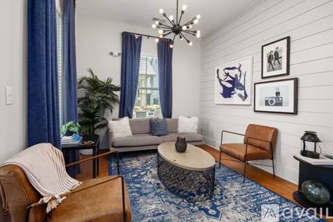 A living room with a couch, chair, and a rug.