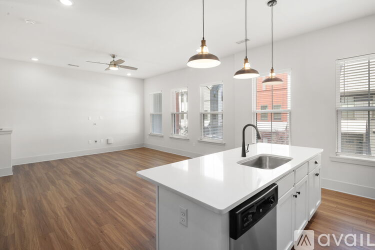 A kitchen with a white countertop and wooden flooring.