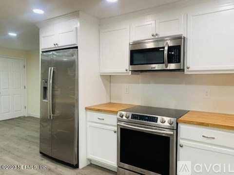 A kitchen with white cabinets and stainless steel appliances.
