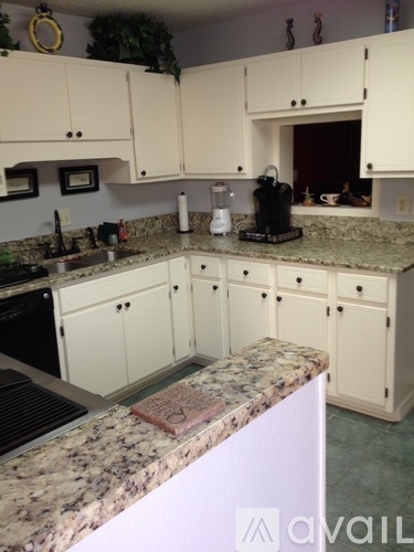 A kitchen with granite countertops and white cabinets.