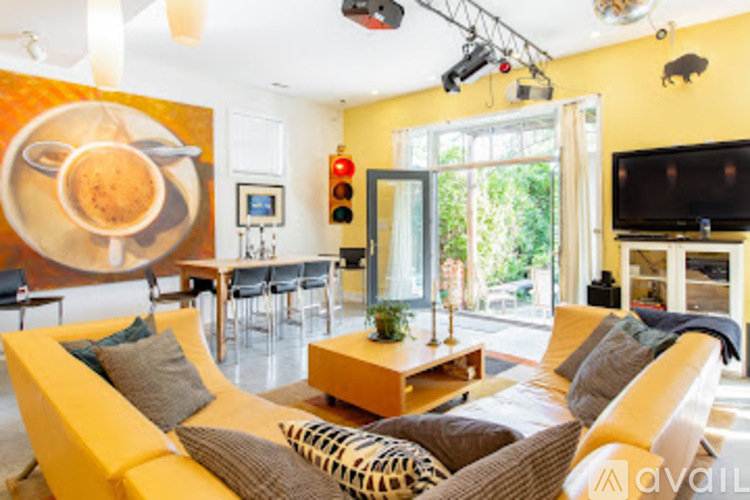 A living room with a yellow couch and a television.
