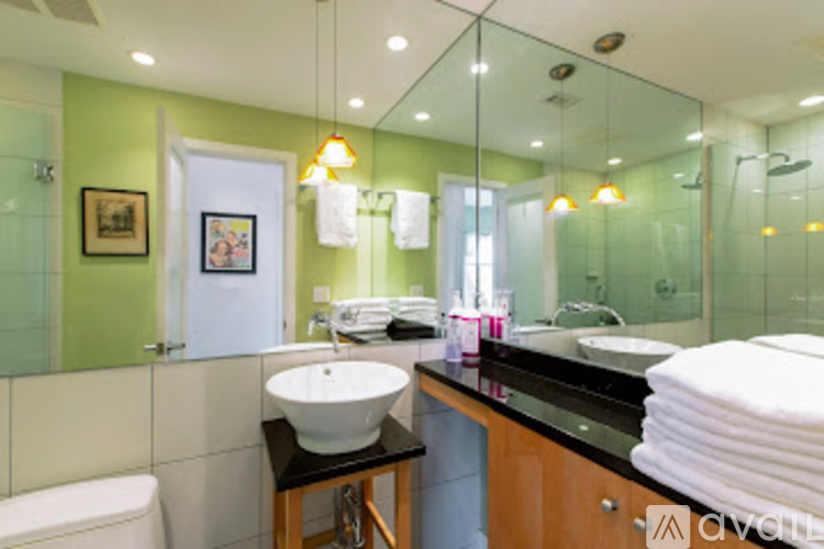 A bathroom with a white sink and a green wall.