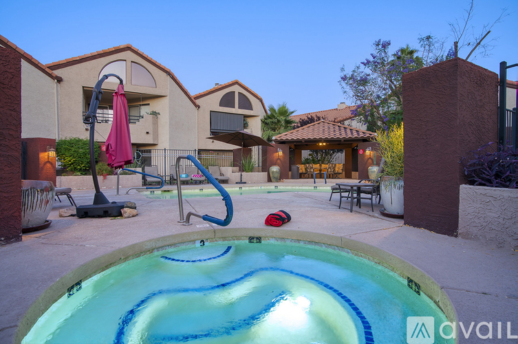 A pool with a slide and a hot tub in front of a house.