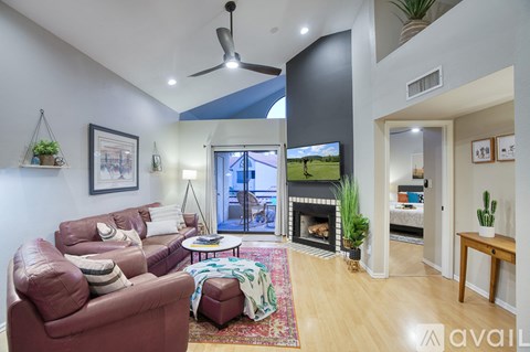 A living room with a red couch and a fireplace.
