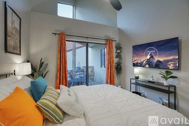 A bedroom with a large bed and a flat screen TV mounted on the wall.