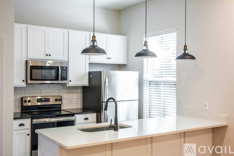 A kitchen with white cabinets and a black refrigerator.