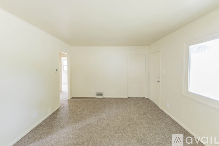 A room with a carpeted floor and white walls.