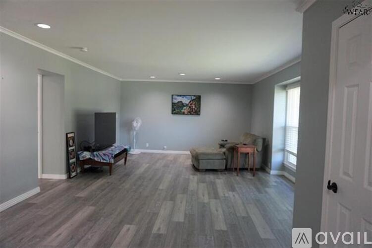 A living room with a grey sofa and a wooden floor.