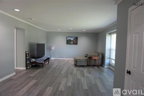 A living room with a grey sofa and a wooden floor.