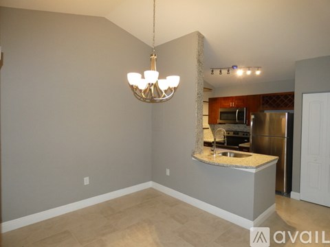 A kitchen area with a counter and a chandelier hanging from the ceiling.