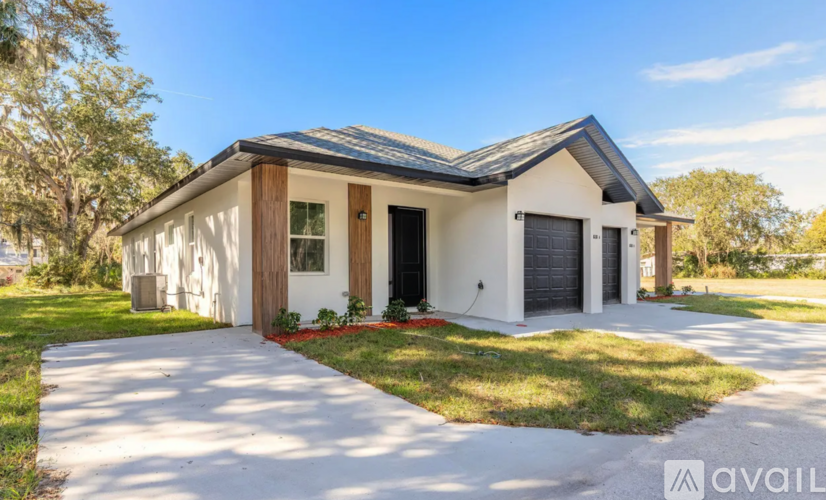 A modern house with a white exterior and a grey roof is available for purchase.