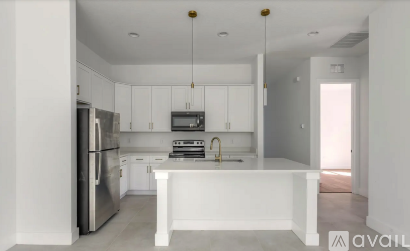 A modern kitchen with white cabinets and stainless steel appliances.