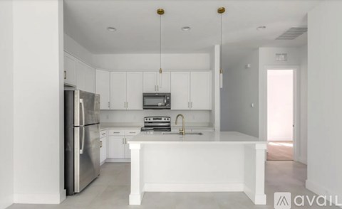 A modern kitchen with white cabinets and stainless steel appliances.