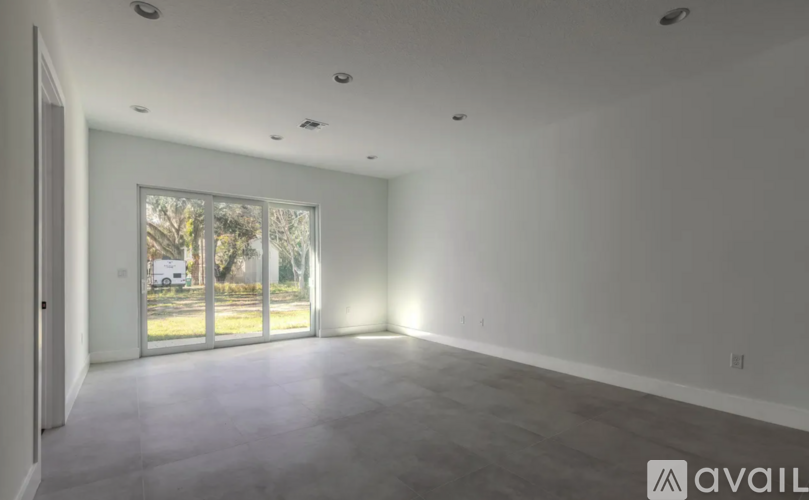 A spacious room with a large window and sliding glass doors.