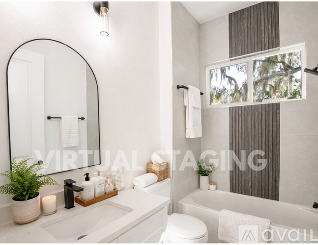 A bathroom with a white sink and a large mirror.