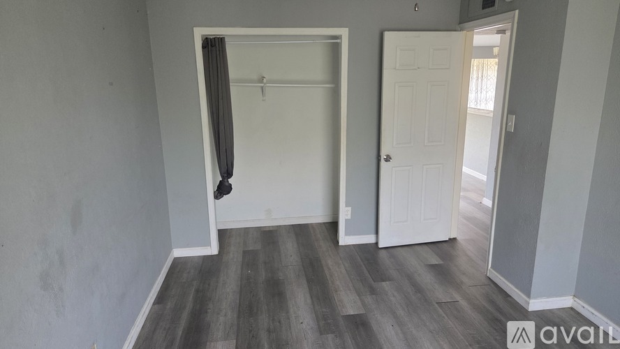 A room with a white door and a grey wall.