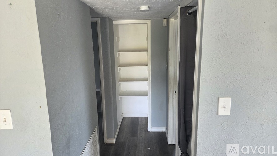 A hallway with a white door and a grey wall.