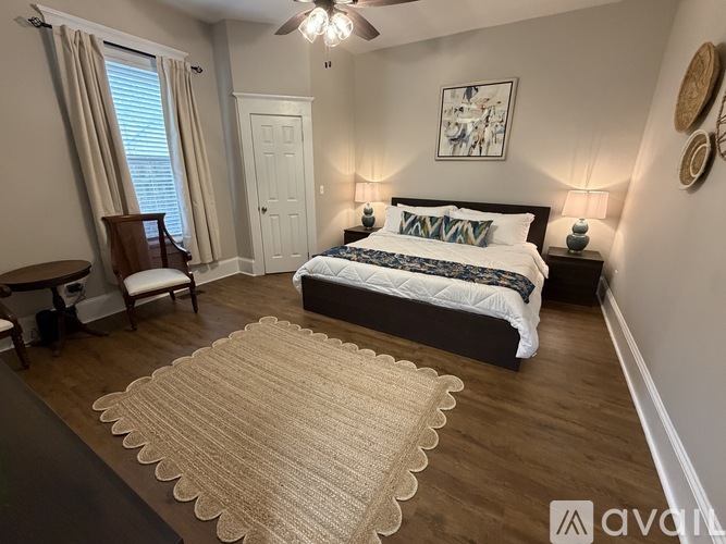 A bedroom with a bed, nightstands, and a rug.