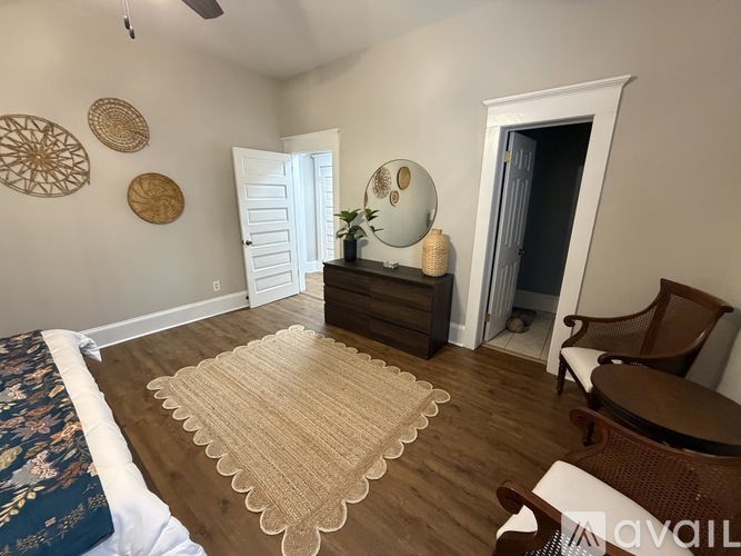 A room with a bed, a dresser, a chair, and a rug.