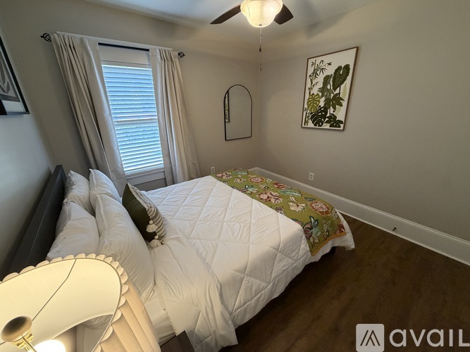 A bedroom with a large bed and a ceiling fan.