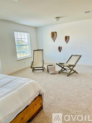 A bedroom with a bed, chair, and wall decorations.