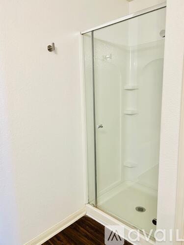 A glass shower door in a white bathroom.