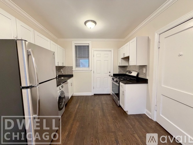 A kitchen with a black fridge and white cabinets.