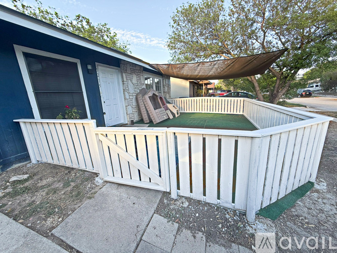 A blue house with a white porch and a green mat.