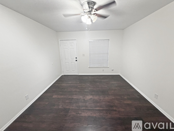 A room with a ceiling fan and wooden flooring.