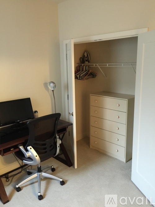 A room with a desk, chair, and a closet.