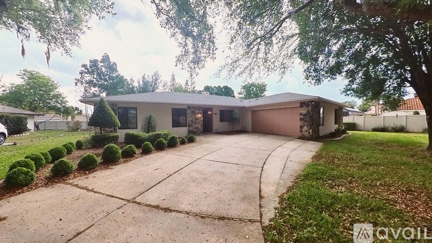 A house with a driveway and a tree in front.