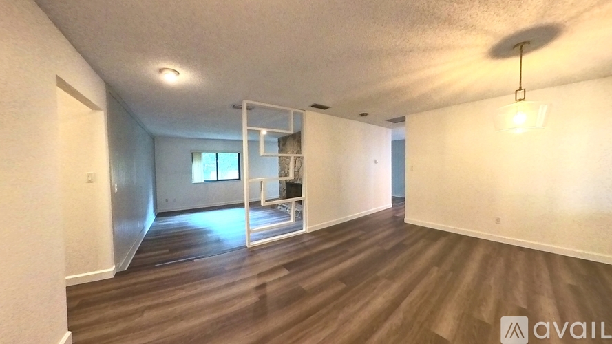 A spacious room with wooden flooring and a white ceiling.