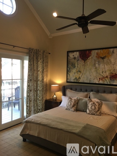 A bedroom with a large bed and a ceiling fan.