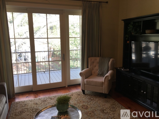 A living room with a chair, a table, and a television.