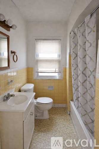A bathroom with a toilet, sink, and shower.